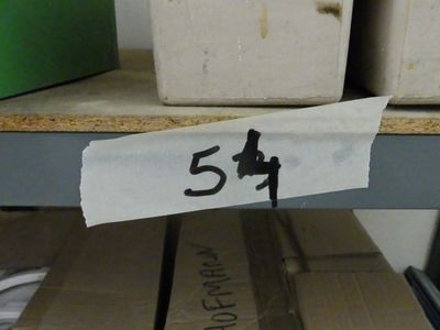une étiquette collée sur un bout de papier posé sur une étagère