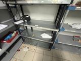 a metal shelf in the middle of a room with a lot of items on it