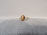 an image of a gold ring with an oval stone in the center
