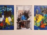 three paintings hanging on the wall of a room