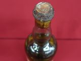 a small brown bottle with a brown lid on a red surface