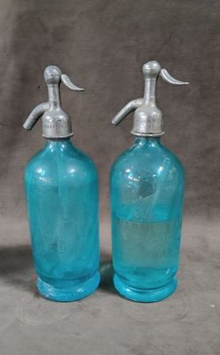 pair of blue glass soap dispensers with metal handles