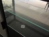 a glass display case in the middle of a tiled floor