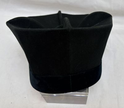 un chapeau noir posé sur un support métallique