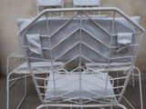 a white metal chair with a white cushion on it