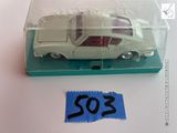 une petite voiture miniature dans une boîte transparente sur laquelle est collé un autocollant