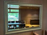 a mirror on the wall above a sink in a bathroom