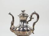 an antique silver tea pot with a handle on a white background