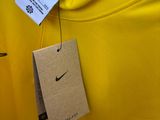 yellow t - shirt with tag on hanger in a store
