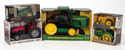 three toy tractors in boxes on a white surface