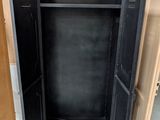 a black cabinet with a door open in a room