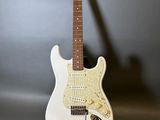 une guitare électrique posée sur une table près d'un mur