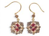 a pair of earrings with pink and white stones on them