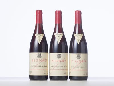 three bottles of red wine are lined up on a table