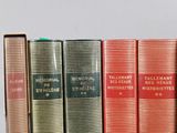 several books are lined up in a row on a shelf