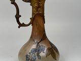 a silver and gold vase with blue flowers on it
