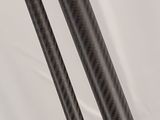 a close up of two black carbon fiber rods on a white background