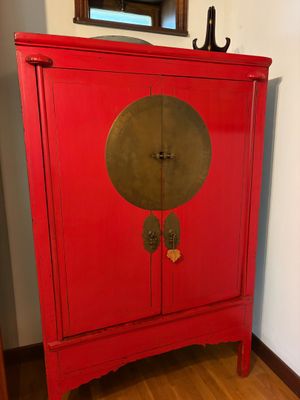 an image of a red cabinet in a room with a mirror