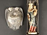 une statue représentant une femme tenant un bébé et un bol