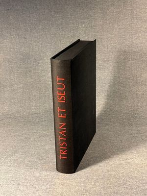 a black book sitting on top of a table next to a gray wall
