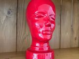 une tête rouge posée sur une étagère en bois munie de crochets