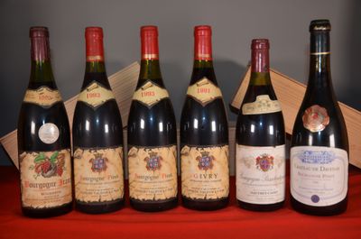 six bottles of wine are lined up on a red table