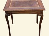 a small wooden table with a leather top on a white background
