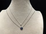 a white mannequin with a blue stone necklace on it