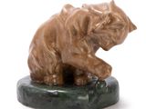 a statue of a cat sitting on a marble base