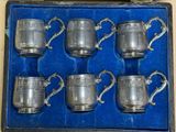 six silverplated cups in a blue box on a table
