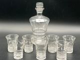 a lot of shot glasses and a decanter on the table