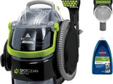 un gros plan sur un aspirateur vert et noir et un flacon de produit nettoyant