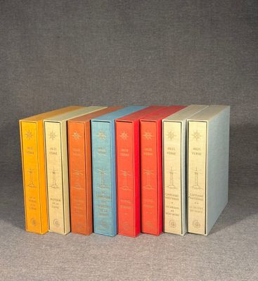 six books are lined up in a row on a gray surface