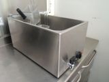 a stainless steel sink in a kitchen with a bottle of water in it