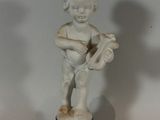 a small statue of a boy holding a guitar