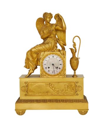 une image représentant une horloge dorée surmontée d'un ange