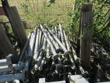 a pile of metal pipes sitting next to a fence