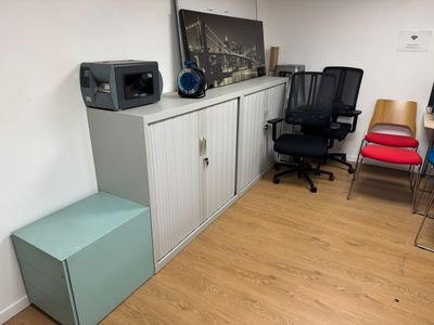 une pièce avec un bureau, une chaise et une télévision accrochée au mur