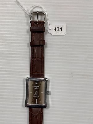 une photo d'une montre avec un bracelet en cuir marron et une boucle argentée