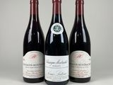 trois bouteilles de vin rouge posées sur une table