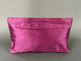 a pink satin clutch bag with a zipper closure