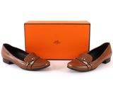 a pair of brown shoes with a box on the side