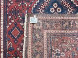 a close up of a red and blue rug on a wooden floor