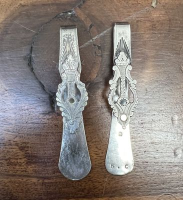 two spoons that are sitting on a wooden table