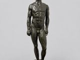 a bronze statue of a man standing on a rock