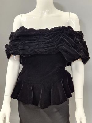 a mannequin wearing a black top and skirt with ruffles
