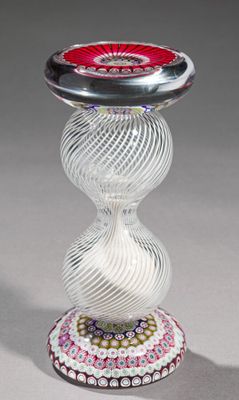 un vase en verre surmonté d'une fleur rouge