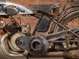 a old motorcycle that is parked in front of a brick wall