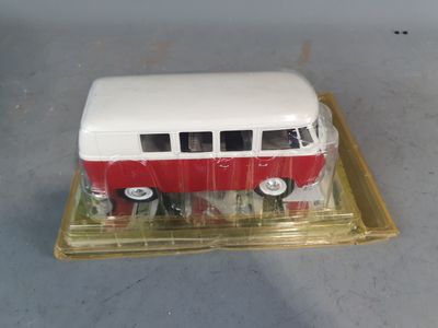 a small red and white bus on a clear tray