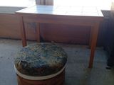 une petite table avec un tabouret devant une fenêtre